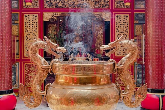 Räucherstäbchen brennen im goldenen Drachenofen im chinesischen konfuzianischen Tempel