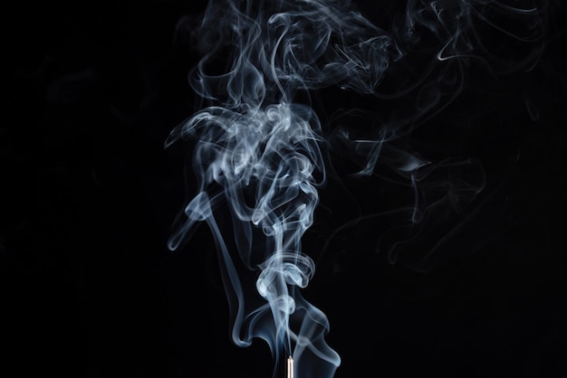Räucherstäbchen mit Rauch auf schwarzem Hintergrund