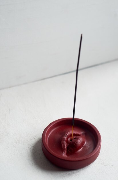 Foto räucherstäbchenständer, rote lippen, runde form auf weißem hintergrund, esoterik-meditation