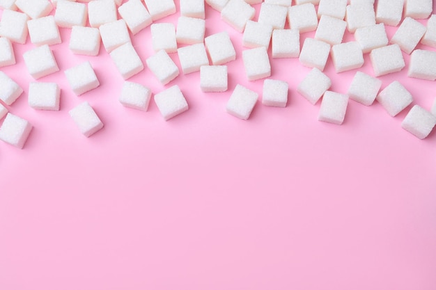 Raffinierte Zuckerwürfel auf rosafarbenem Hintergrund über der Ansicht Platz für Text
