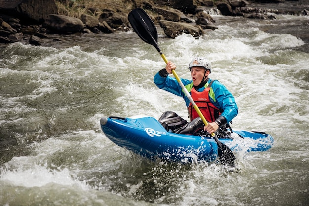 Rafting extremo Una persona en práctica de kayak atravesando los rápidos de agua Concepto de kayak