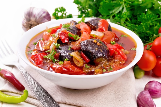 Ragú de verduras con berenjenas, tomates, pimientos, cebollas y especias en un plato