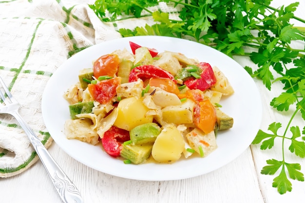 ragú de verduras con calabacín, col, patata, tomate, pimiento en salsa cremosa en plato a bordo