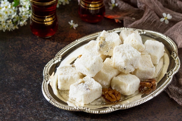 Rahat Lokum con nueces en la mesa de la cocina. Dulces turcos y árabes. Comida de Ramadán. Copie el espacio.