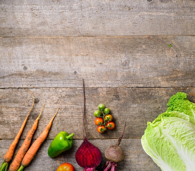 Rahmen aus frischem Tomaten-Kohl-Gurken-Papier, Knoblauch und Rüben auf Holztisch-Draufsicht