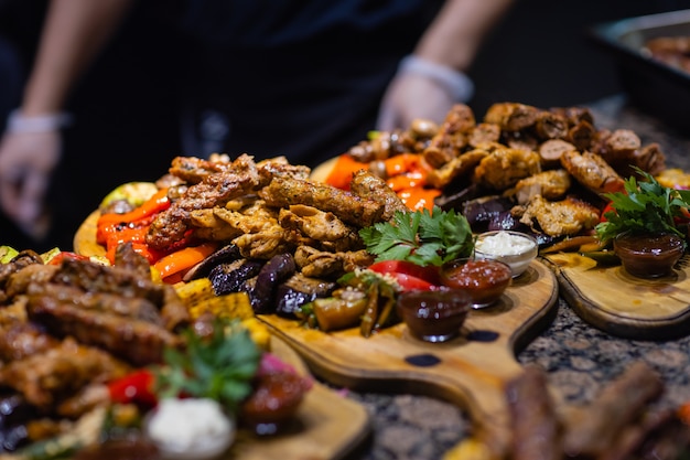 Rahmen aus gegrilltem Steak, gegrilltem Gemüse, Kartoffeln, Salat, verschiedenen Snacks und hausgemachter Limonade, Draufsicht. Konzept Esstisch.