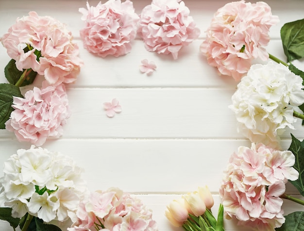 Rahmen aus rosa und beigen Hortensienblüten und gelben Tulpen