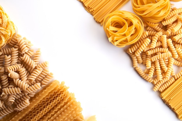 Rahmen aus verschiedenen Sorten von Nudeltapeten. Mischen Sie Makkaroni, Spaghetti auf weißem Hintergrund mit Kopierraum