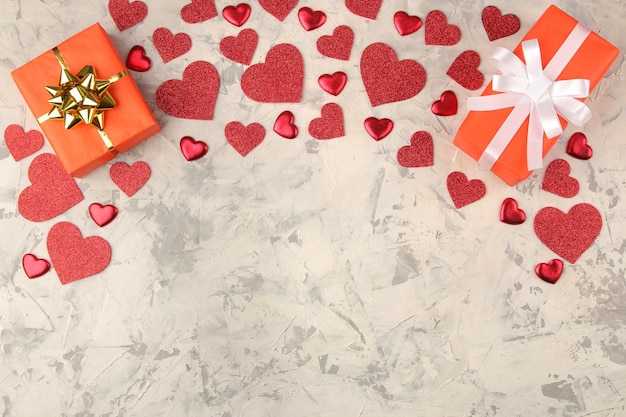 Rahmen der Geschenkbox und der Herzen auf einem hellen konkreten Hintergrund Valentinstag.
