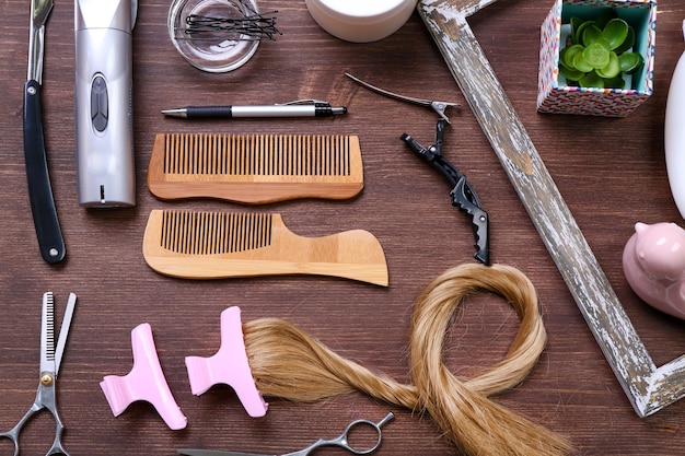 Rahmen mit Haarsträhnen Friseurwerkzeugen Ausrüstung und Kosmetik auf Holzhintergrund