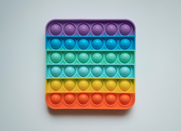 Rainbow Anti-Stress-Finger-Push-Spielzeug für Kinder knallen es isoliert auf weißem Hintergrund.