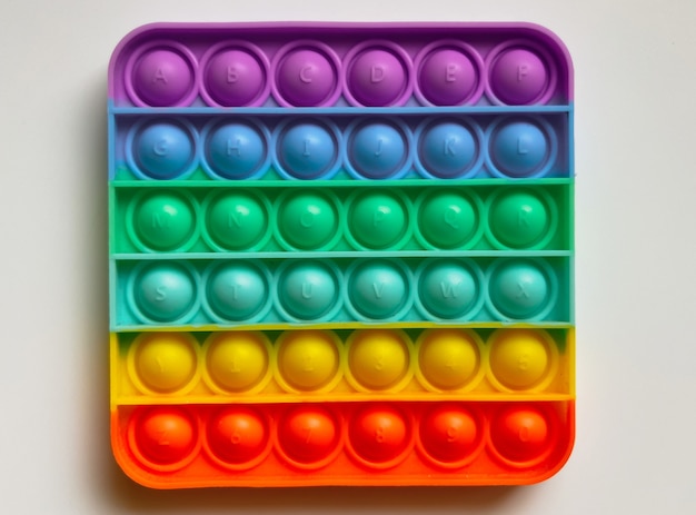 Rainbow Anti-Stress-Finger-Push-Spielzeug für Kinder knallen es isoliert auf weißem Hintergrund.