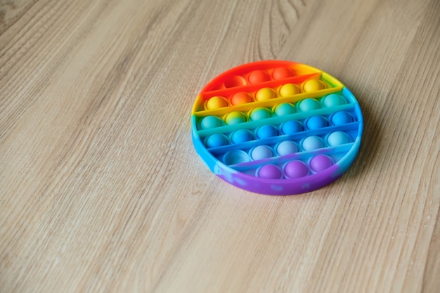 Rainbow Pop it fidget toy en el piso de la casa o la escuela