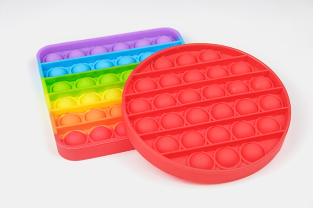 Rainbow Square y Red Round Fidget Toys Popit sobre el fondo blanco.