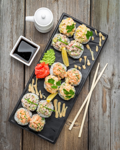 Rainbow Sushi Roll con salmón, anguila, atún, aguacate, langostino real, queso crema Philadelphia, caviar tobica, chuka. Menú de sushi. Comida japonesa.