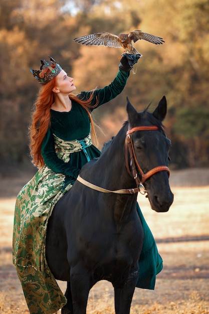 Rainha com cabelo ruivo em um vestido verde e coroa com um cavalo e um pássaro
