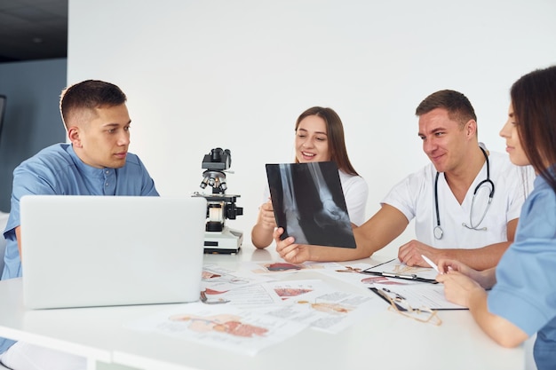 Raio X de pernas Grupo de jovens médicos está trabalhando juntos no escritório moderno