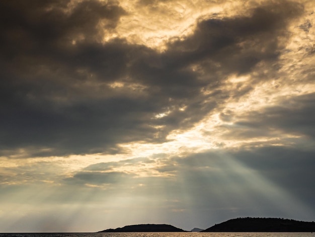 Raios de sol das nuvens para o mar