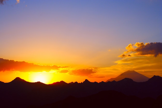 Raios de sol iluminando a encosta de uma montanha Elbrus