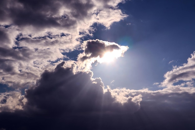 Raios do sol da noite rompem nuvens de tempestade azuis em uma noite de primavera