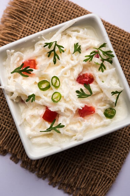 Raita de rábano o Daikon o Mooli Koshimbir servido en un cuenco sobre un fondo de mal humor. Enfoque selectivo. Comida sana india