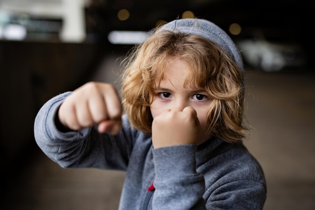 Foto raiva agressiva criança menino menino raiva na rua menino zangado mostrando punho retrato de