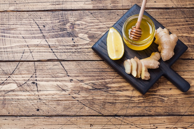 Raiz de gengibre e mel de limão na superfície de madeira