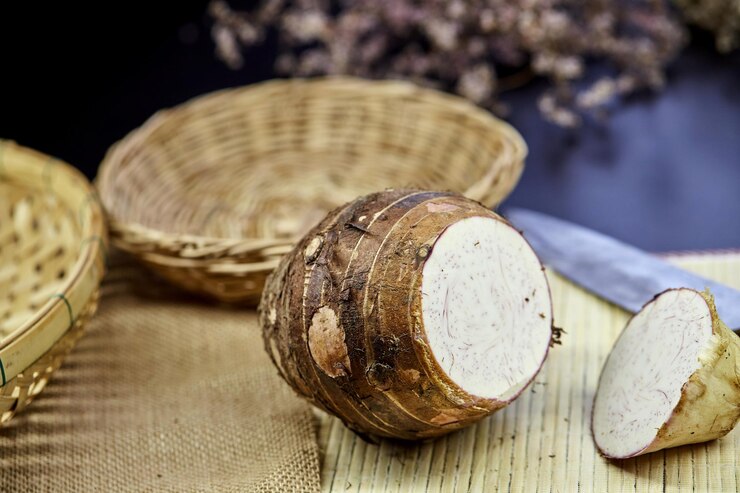 Foto raiz de taro marrom orgânica crua picada em tapete de bambu