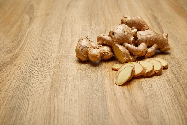 Foto raíz de jengibre en rodajas en la mesa de madera