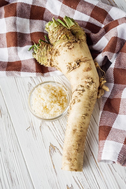 raíz de rábano picante aromática sobre un fondo de madera rústica blanca