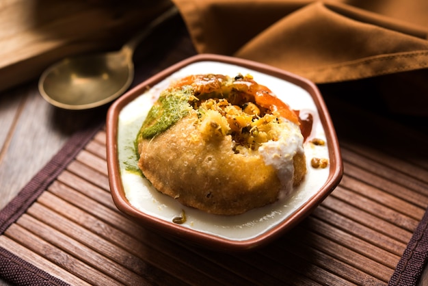 Raj Kachori servido con dahi o cuajada y chutney de imli. Enfoque selectivo y fondo cambiante