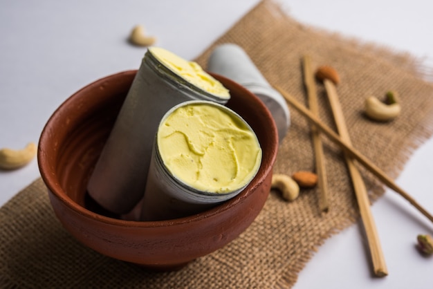 Foto rajasthani casero listo para comer matka kulfi - azafrán o kesariya con sabor a pistacho, anacardo y almendras, enfoque selectivo