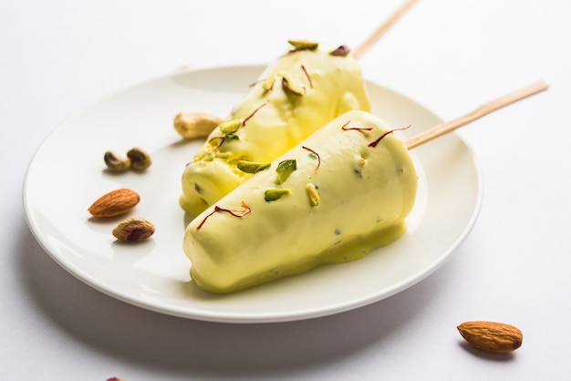 Rajasthani casero listo para comer matka kulfi - azafrán o kesariya con sabor a pistacho, anacardo y almendras, enfoque selectivo