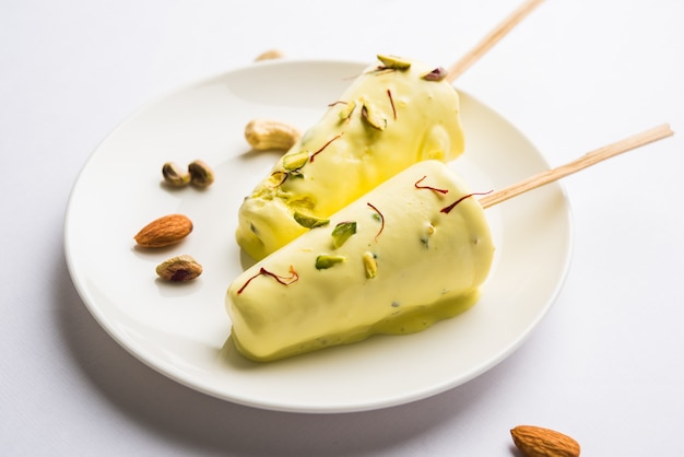 Rajasthani casero listo para comer matka kulfi - azafrán o kesariya con sabor a pistacho, anacardo y almendras, enfoque selectivo