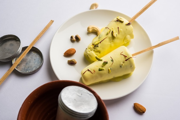 Rajasthani hausgemacht verzehrfertig Matka Kulfi - Safran oder Kesariya gewürzt mit Pistazien, Cashew und Mandeln, selektiver Fokus