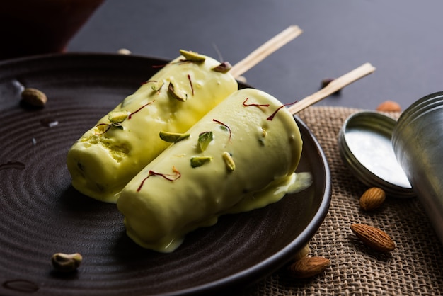 Rajasthani hausgemachte verzehrfertige Matka Kulfi - Safran oder Kesariya mit Pistazien-, Cashew- und Mandelgeschmack, selektiver Fokus