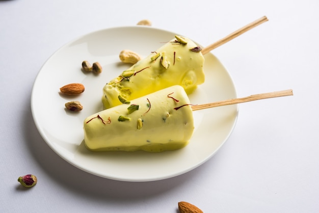 Rajasthani hausgemachte verzehrfertige Matka Kulfi - Safran oder Kesariya mit Pistazien-, Cashew- und Mandelgeschmack, selektiver Fokus