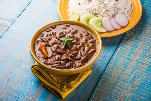 Rajma oder Razma ist ein beliebtes nordindisches Essen, das aus gekochten roten Kidneybohnen in einer dicken Soße mit Gewürzen besteht. Serviert in einer Schüssel mit Jeera Reis und grünem Salat