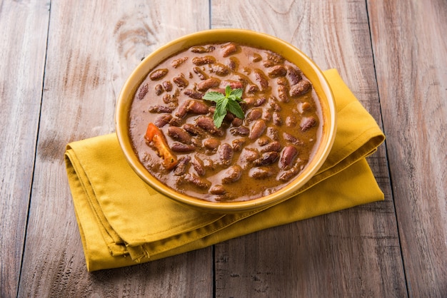 Rajma oder Razma ist ein beliebtes nordindisches Essen, das aus gekochten roten Kidneybohnen in einer dicken Soße mit Gewürzen besteht. Serviert in einer Schüssel mit Jeera Reis und grünem Salat