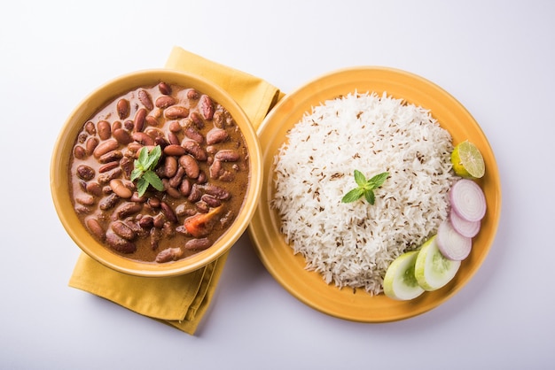 Foto rajma or razma é um alimento popular do norte da índia, que consiste em feijão vermelho cozido em um molho espesso com especiarias. servido em tigela com arroz jeera e salada verde
