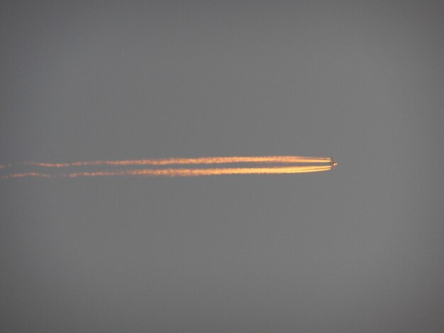 Rakete mit orangefarbener Dampfspur gegen klaren Himmel