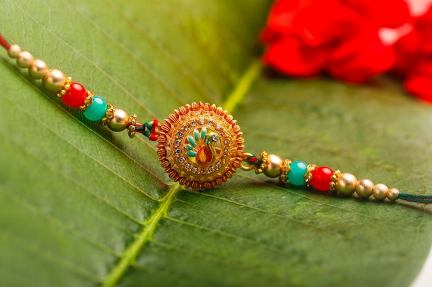 Foto rakhi decorativo o pulsera en el concepto de raksha bandhan del festival indio de hoja verde