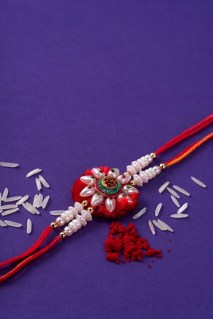 Rakhi mit Reiskörnern und Kumkum. Ein indischer festlicher Hintergrund