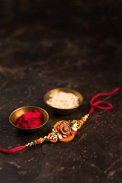 Raksha Bandhan com um elegante Rakhi, grãos de arroz e Kumkum. Pulseira tradicional indiana, símbolo de amor entre irmãos e irmãs.