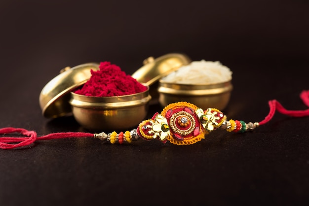 Raksha Bandhan con un elegante Rakhi, granos de arroz y kumkum