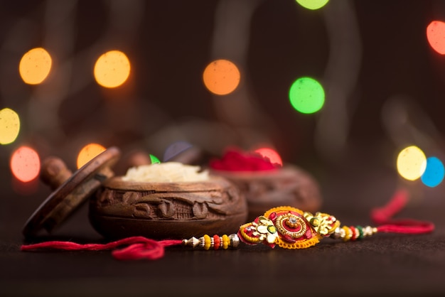 Raksha Bandhan Feier mit einem eleganten Rakhi, Reiskörnern und Kumkum. Ein traditionelles indisches Armband, das ein Symbol der Liebe zwischen Brüdern und Schwestern ist.