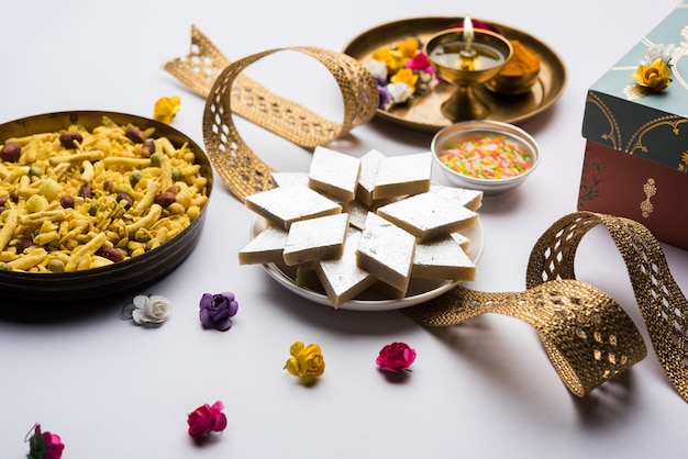 Raksha Bandhan Festival Grüße: konzeptionelles Rakhi mit einem Teller voller Kaju Katli Barfi oder Burfi und ausgefallener Band und Pooja Thali. selektiver Fokus