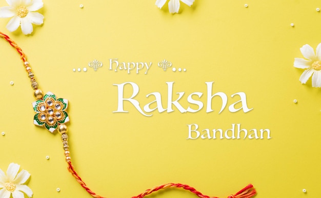 Foto raksha bandhan festival indiano com bonito rakhi e grãos de arroz em fundo amarelo uma pulseira tradicional indiana que é um símbolo de amor entre irmãs e irmãos