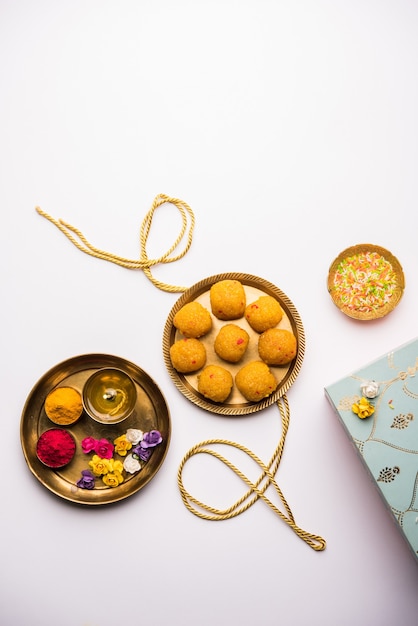 Raksha-Bandhan-Festival: konzeptionelles Rakhi, das mit einem Teller voller Bundi Laddu-Süßigkeiten mit Band und Pooja Thali hergestellt wird. Ein traditionelles indisches Armband - Symbol der Liebe zwischen Bruder und Schwester