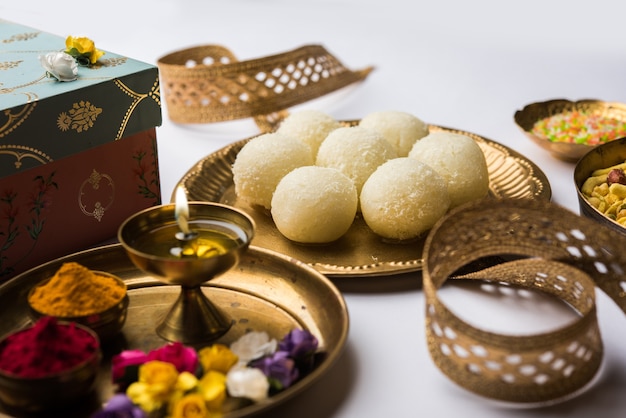Raksha bandhan Festival: Rakhi conceitual feito em prato cheio de doce Rasgulla com banda. Uma pulseira tradicional indiana que é um símbolo de amor entre irmãos e irmãs